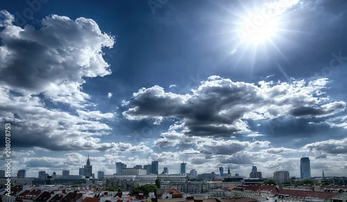 Fototapeta Panorama Warszawy z ciemnymi chmurami i słońcem