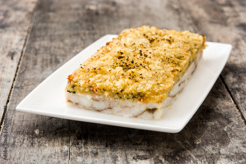 White fish casserole with cheese on wooden background.