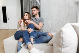Happy young couple hugging while sitting together on a couch