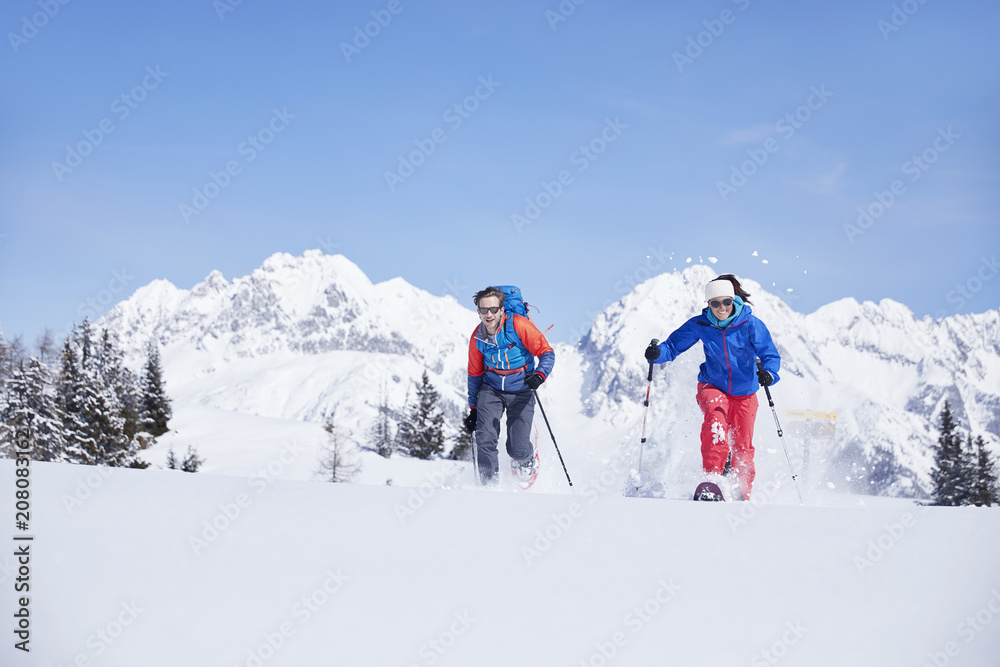 Austria, Tyrol, snowshoe hikers running through snow