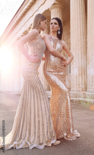 beautiful young women with dark hair in luxurious evening dresses