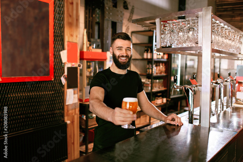 Bild auf Leinwand Bartender With Beer In Glass In Pub