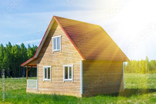 Деревянный дом с крыльцом на лугу, на фоне зелёных деревьев и голубого неба с солнечными лучами