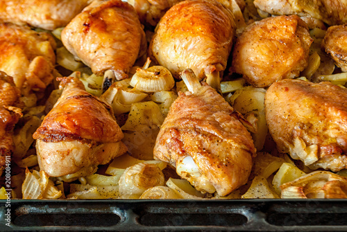 Chicken legs on a potato-onion cushion on a metal baking sheet