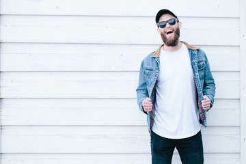 Hipster man walking wearing black jeans, t-shirt and a baseball cap