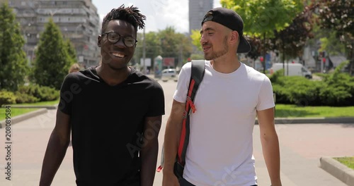 Men friends walking, pat on the shoulder and talking