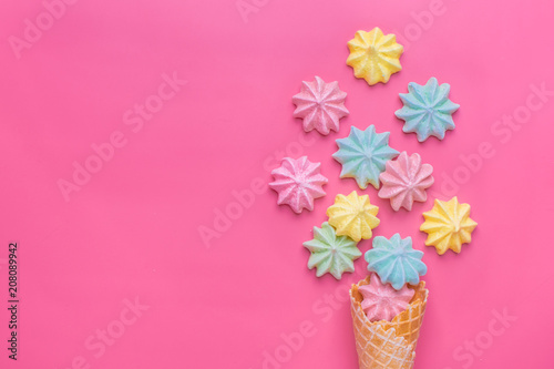 Ice cream cone with pink,blue, yellow meringues on a  colorful  background. Sweet summer concept. Top view. Flat lay.Pastel colors.Dessert © bmarya83