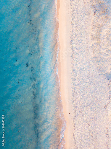 Aerial view of turquoise water and white sand.