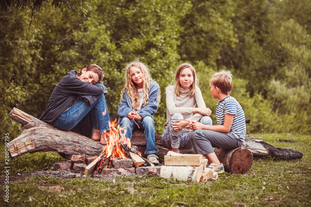 Children in the camp by the fire - obrazy, fototapety, plakaty 