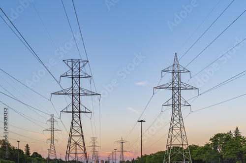 Electrical poles and power lines in a  suburbian area at sunset
