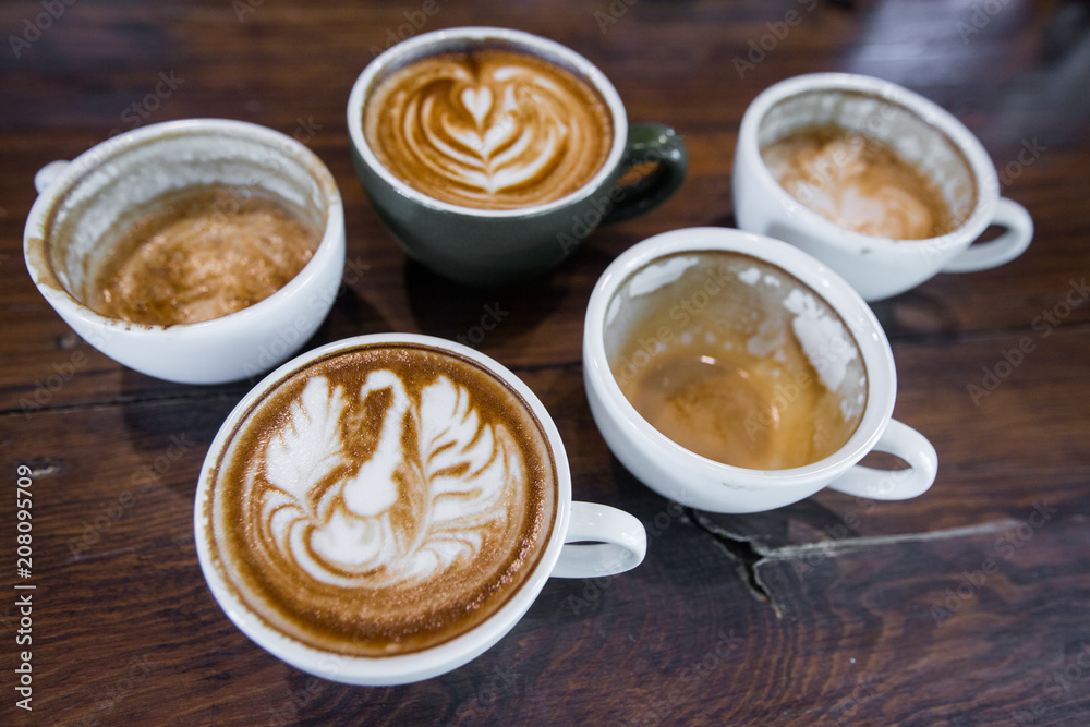Coffee workshop top view of Coffee cup with latte art on wooden table . Selective focus white cup.color vintage style. Coffee workshop top view of Coffee cup with latte art on wooden table . Selective focus white cup.color vintage style.