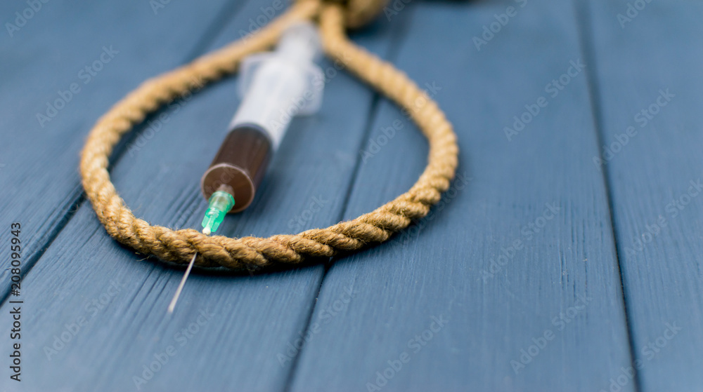 The concept of suicide from drugs. A syringe in a loop for the gallows.
