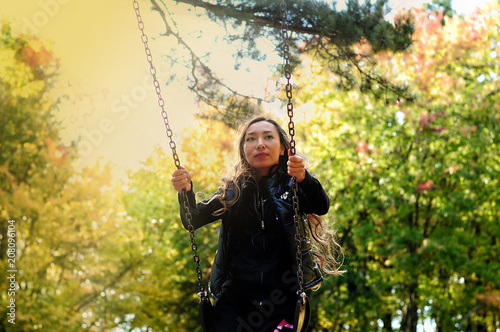 A girl of oriental appearance skates on a swing. 