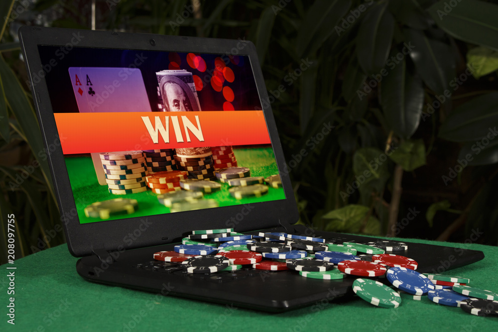 Fototapeta premium A lot of poker chips on the laptop with the inscription 