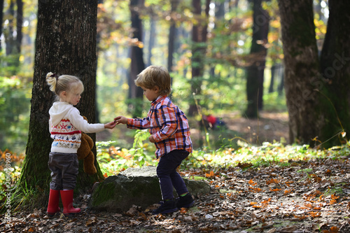 Little boy and girl friends camping in woods. Childhood and child friendship, love and trust. Brother and sister have fun on fresh air. Children play in autumn forest. Kids activity and active rest