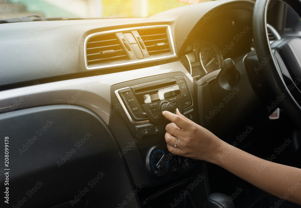 Hand female driver touching the screen and turning on car radio system,Button on dashboard in new car panel