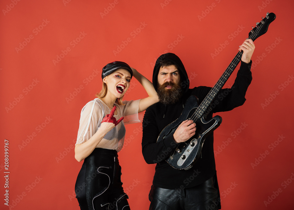 Rock couple of sexy girl and bearded man with guitar. cool rock and roll couple on red background. Stylish hipster and woman together with electric guitar. guitarists of rock band with guitar. music.