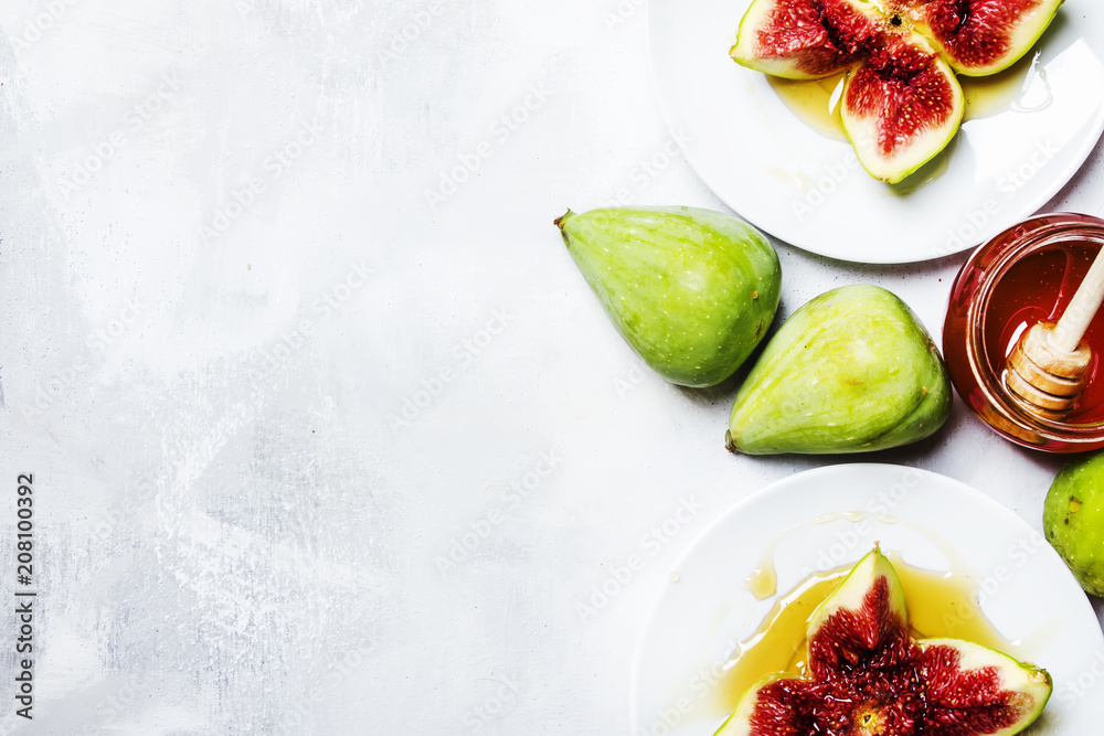 Sweet fresh green figs with honey, summer dessert, gray stone background, top view Sweet fresh green figs with honey, summer dessert, gray stone background, top view