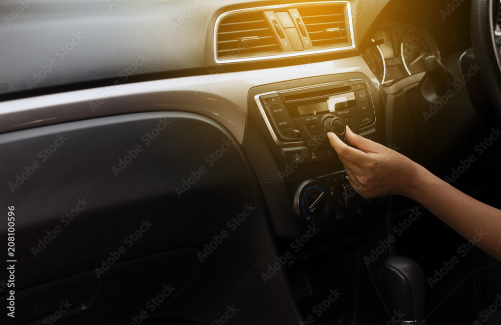 Foto de Button on dashboard in car panel,Hand turning on car radio