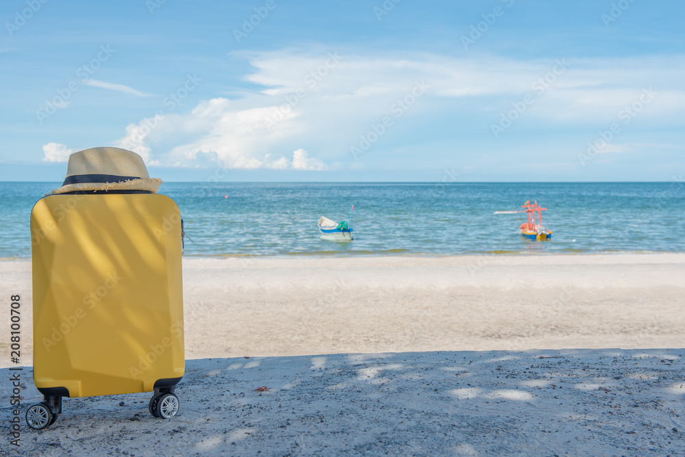 Traveling suitcase with hat on the beach, traveling and relaxing time concept. Traveling suitcase with hat on the beach, traveling and relaxing time concept.
