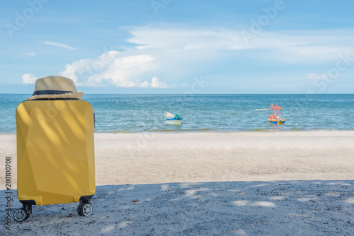 Traveling suitcase with hat on the beach  traveling and relaxing time concept.