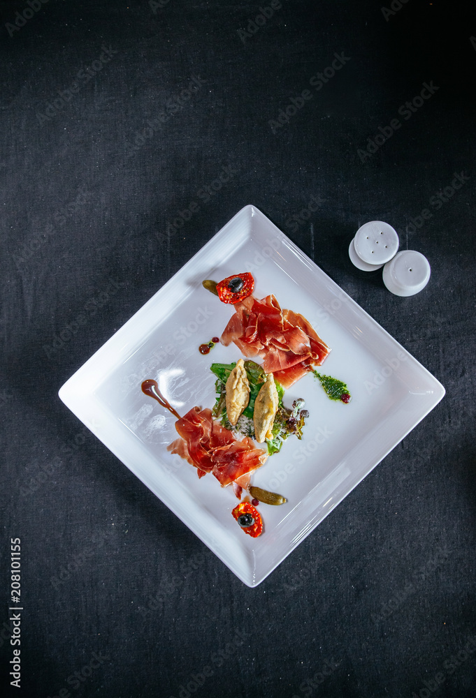 Tasty green mix salad with prosciutto ham, sundried tomato, black olive and parmesan cheese
