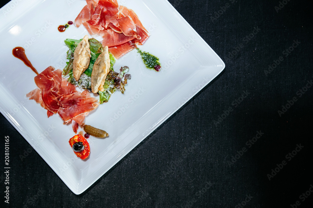 Tasty green mix salad with prosciutto ham, sundried tomato, black olive and parmesan cheese Tasty green mix salad with prosciutto ham, sundried tomato, black olive and parmesan cheese