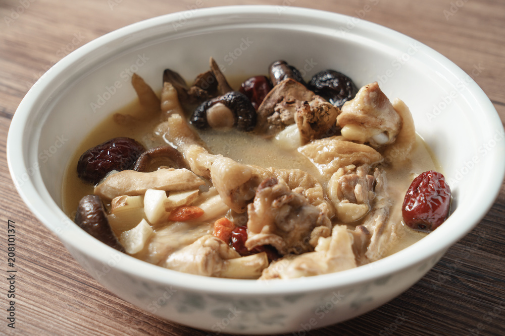 A nutritious chicken soup with a woody background A nutritious chicken soup with a woody background