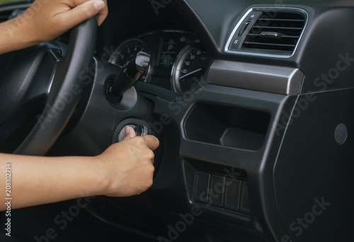 Hand woman driver holding car keys and start the engine with modern car