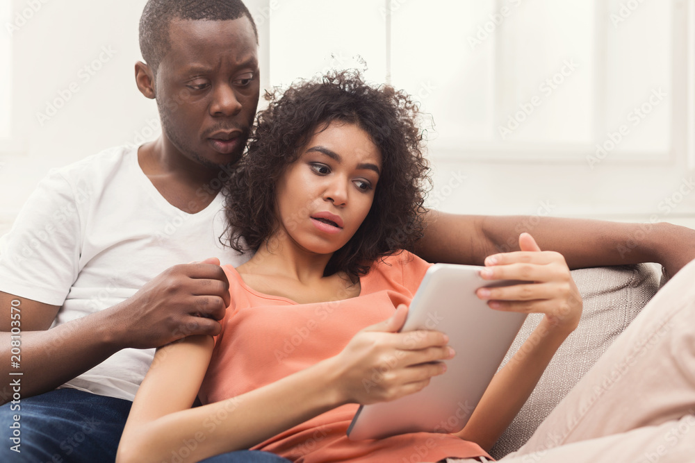 Black couple using digital tablet at home Black couple using digital tablet at home
