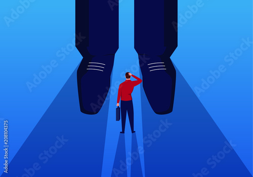 Businessman stands at the feet of giants photo