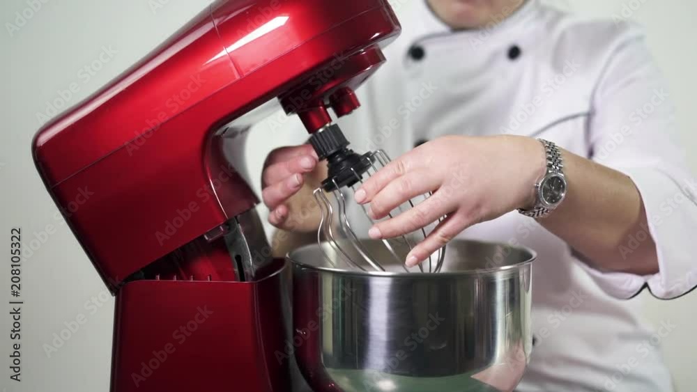 Confectioner-baker preparing red kitchen mixer for whipping cream. Woman cooking delicious desserts Confectioner-baker preparing red kitchen mixer for whipping cream. Woman cooking delicious desserts