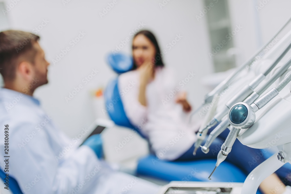 dental tools with doctor talking with patient dental tools with doctor talking with patient