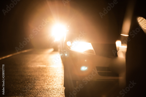 Halogen headlight lamps of cars in the night. photo