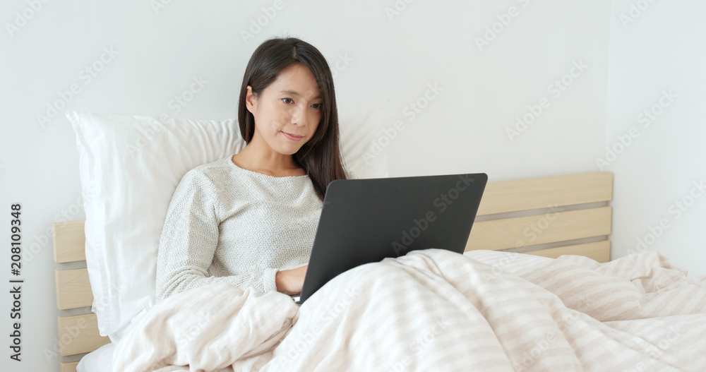Woman working laptop computer on bed Woman working laptop computer on bed