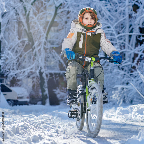 Young boy riding bike in beautiful winter city