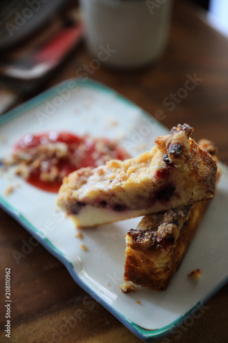 Dessert Blueberry cheese cake with strawberry jam on wood table background