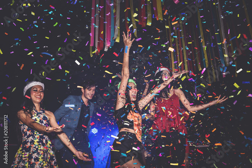 Cheerful Party People Dancing and Throwing Colorful Confetti in Nightclub - Lifestyle Concept