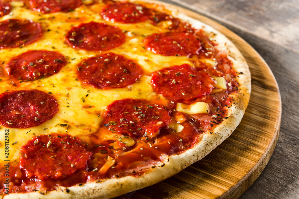 Hot italian pepperoni pizza on wooden table
