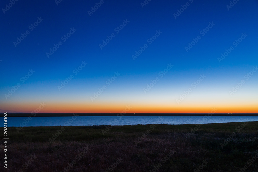 Gradient sunrise sky showing blue, yellow and orange layer