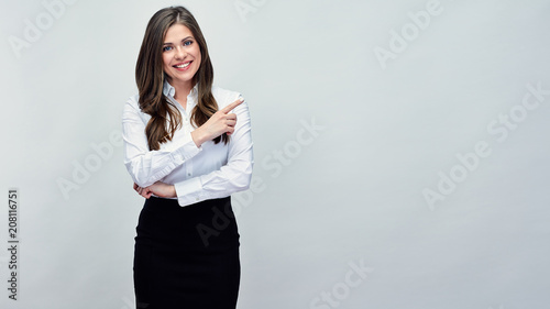 Smiling woman pointing with finger at copy space.