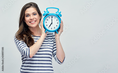 Smiling woman holding big alarm clock.