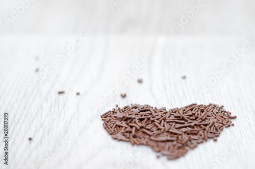 chocolate chips arranged into a heart shape on wight table photo