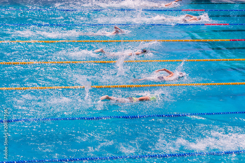 Young swimmers in outdoor swimming pool during competition. Health and fitness lifestyle concept with kids.