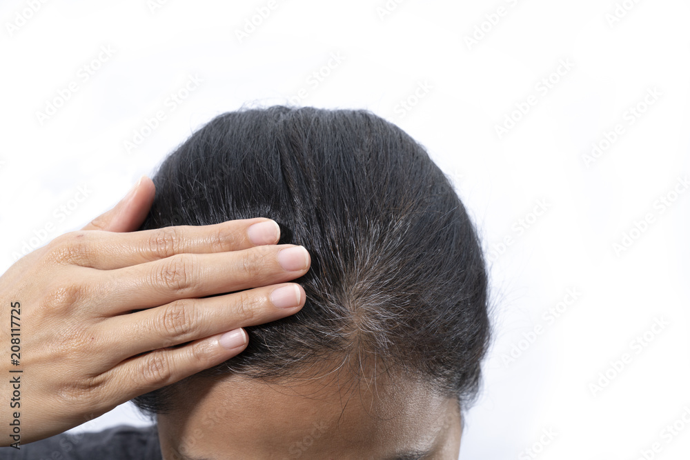 Fototapeta premium Young woman shows her gray hair roots isolated on white background