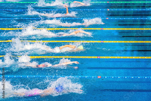 Young swimmers in outdoor swimming pool during competition. Health and fitness lifestyle concept with kids.