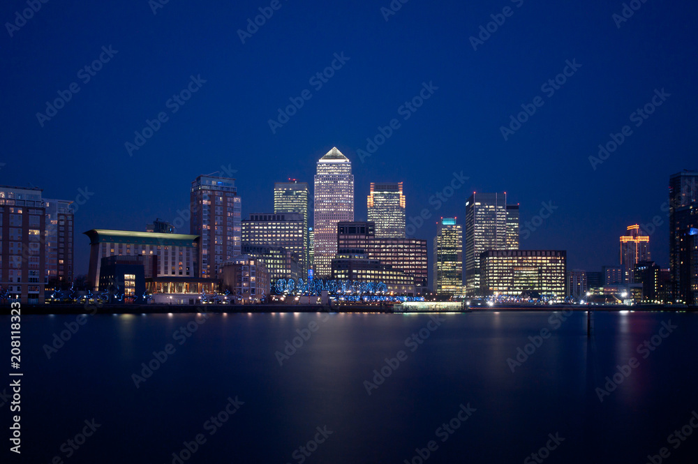 London financial district skyline. Canary Wharf at night with illuminated skyscrapers