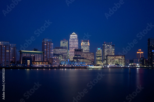 London financial district skyline. Canary Wharf at night with illuminated skyscrapers