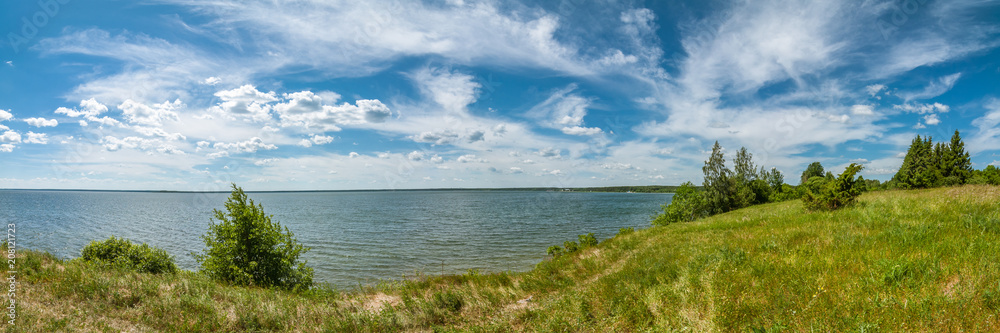 summer landscape. panoramic view of the lake under a beautiful cloudy sky with a coast in the foreground