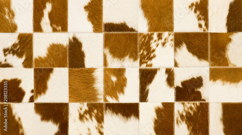 Fotografija Close-up of southwest craftsman sewn square pieces of cowhide with brown and white hair